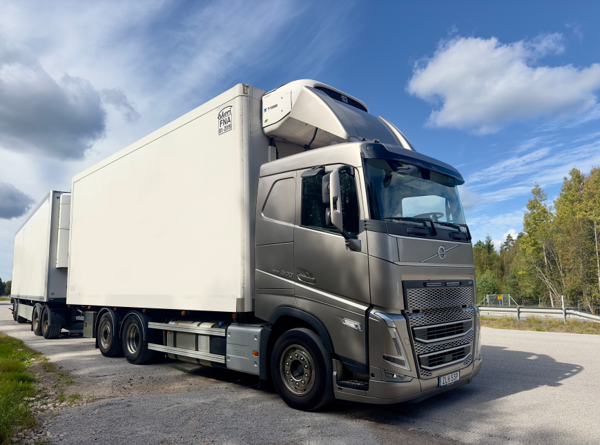 En lastbil med dubbla släp vid vägkanten.